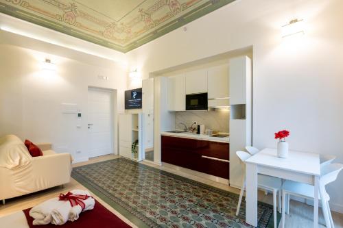 a living room with a table and a kitchen at Principe del Pardo in Catania