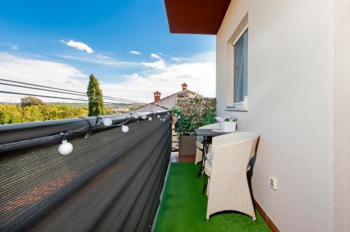 a balcony with a table and chairs on a building at Apartment Studio Lara in Rovinj