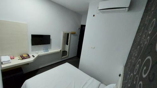 a small room with a bed and a mirror at Aura Syaria Guest House in Bukittinggi