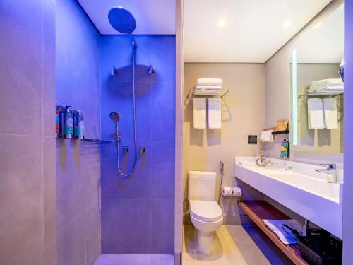 a bathroom with a shower and a toilet and a sink at Grand Mercure SP Itaim Bibi in Sao Paulo
