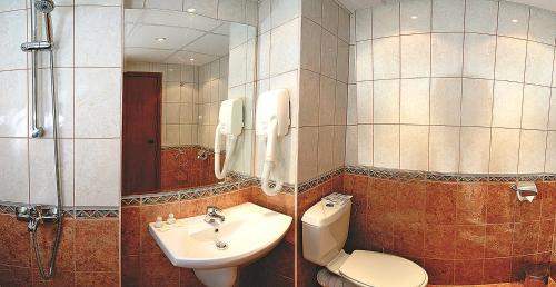 y baño con lavabo, aseo y ducha. en Hotel Exotica en Golden Sands