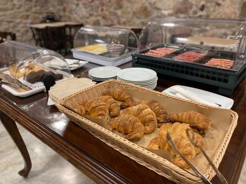 una mesa con cestas de cruasanes y otros pasteles en Hotel Cantón, en Barcelona