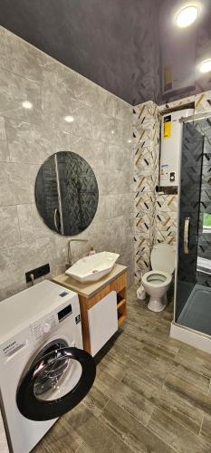 a bathroom with a washing machine and a toilet at Wood Appartment on Svobody in Kamianske