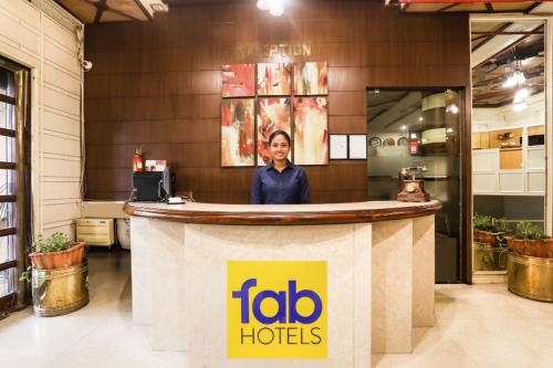 a woman standing behind a counter at a fida hotel at FabHotel Darshan Tower in Nagpur