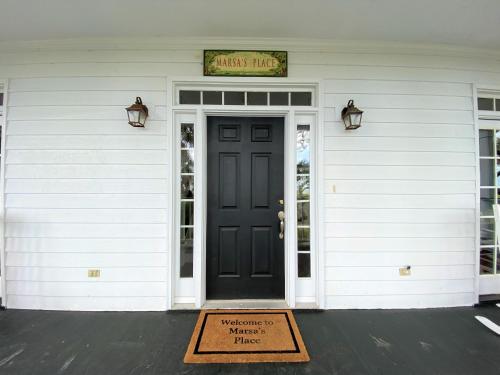 a sign on the door of a house with a welcome mat at Marsa's Place in Edisto Island