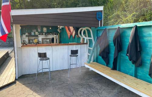 un bar dans un hangar avec deux tabourets dans l'établissement 3 Bedroom Cozy Home In Farsund, à Helle