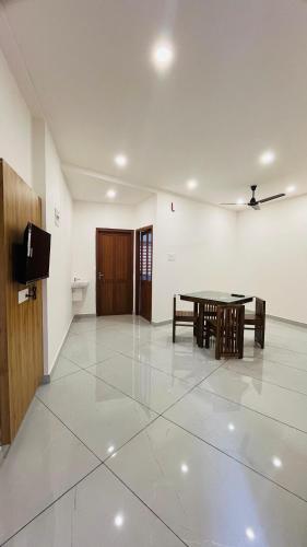 a dining room with a table and a tv at LF Apartment in Kozhikode