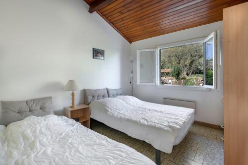 ein Schlafzimmer mit zwei Betten und einem Fenster in der Unterkunft 800 m de la plage, jardin, maison pour 5 in Saint-Michel-Chef-Chef