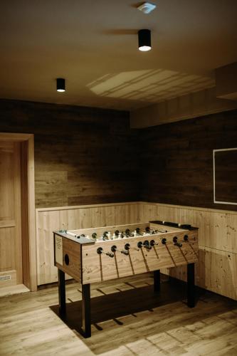 a large game table in a room with wooden walls at eM Apartments Javorník in Vacov