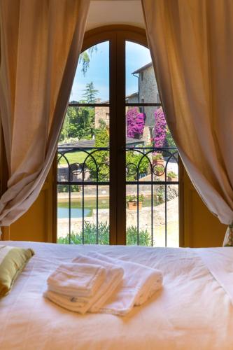 a bed with two towels sitting on it in front of a window at Bertolli Villas in Matraia
