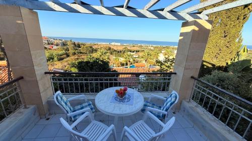 a balcony with a table and chairs and the ocean at Private House in Paphos in Khlorakas