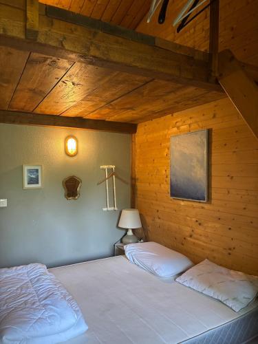 a bedroom with two beds in a wooden wall at Maisonnette deux chambres au fameux PAS DE ROLAND in Itxassou