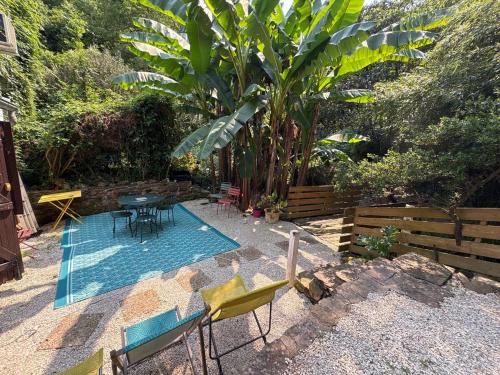 a patio with a table and chairs in a yard at Maisonnette deux chambres au fameux PAS DE ROLAND in Itxassou