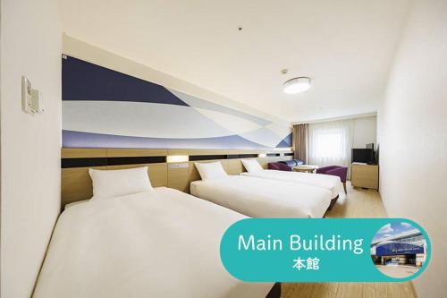twee bedden in een hotelkamer met de tekst hoofdgebouw bij HOTEL DREAM GATE maihama in Urayasu