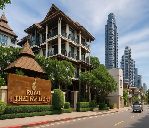 a building on a street with a sign in front of it at Royal Thai Pavilion Jomtien Hotel in Jomtien Beach