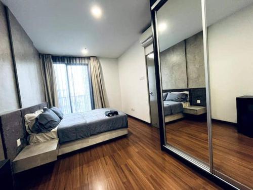 シャー・アラムにあるFirst Residence at i-City Shah Alamのベッドと大きな鏡のある寝室