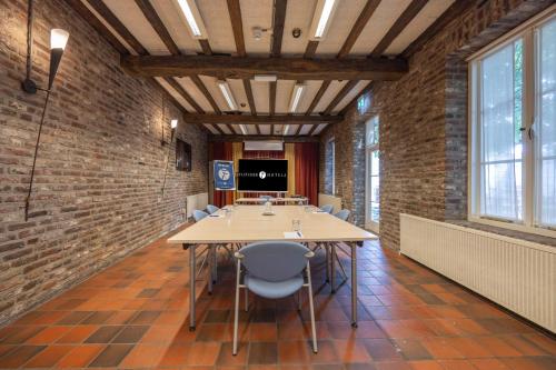 a conference room with a long table and chairs at Fletcher Hotel La Ville Blanche in Thorn