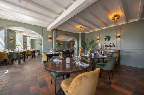 a dining room with tables and chairs in a restaurant at Fletcher Hotel La Ville Blanche in Thorn