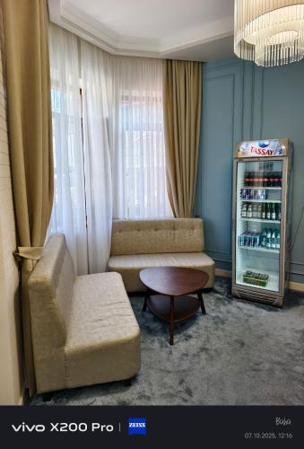 a living room with a couch and a drink refrigerator at Radamis Hotel in Almaty