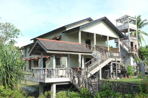 a house with a staircase leading up to it at Sepat Village House by the Beach in Kuantan