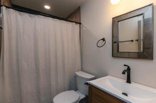 a bathroom with a toilet and a sink and a mirror at Sulla Sabbia in Edisto Island
