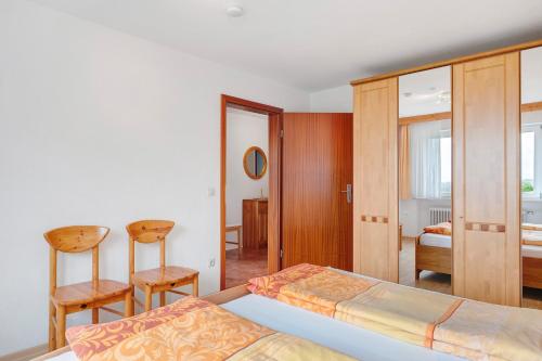 a bedroom with a bed and two chairs at Ferienwohnungen Tröndle in Weilheim