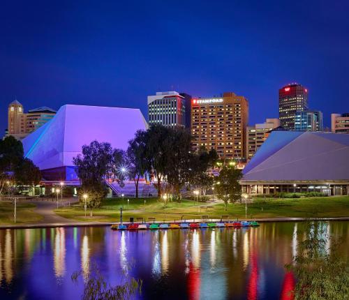 um horizonte da cidade à noite com um rio e edifícios em Stamford Plaza Adelaide em Adelaide