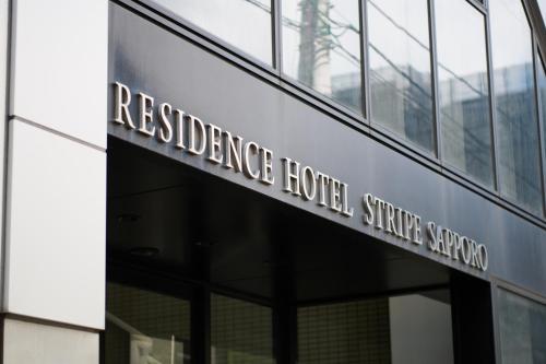 a sign for the headquarters of reliance hotel singapore on a building at Hotel Stripe 札幌 in Sapporo