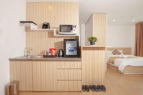 a hotel room with a bed and a counter with a television at Gardenia Hue Hotel in Hue