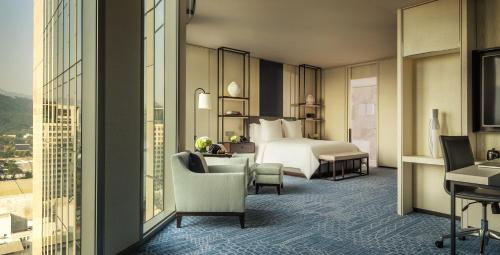 a hotel room with a bed and a desk and chairs at Four Seasons Hotel Seoul in Seoul