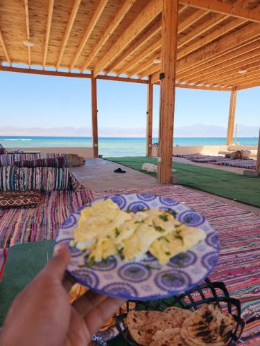 a person holding a plate of food on a table at Southern spirit in Nuweiba
