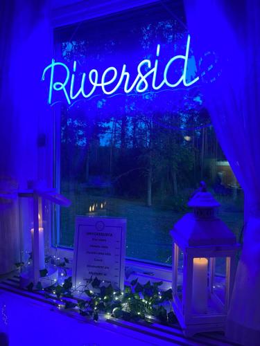 a lit up sign in a window in a room at The Riverside in Undrom