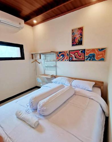 a bedroom with two beds and a window at Satera Homestay in Seteluk