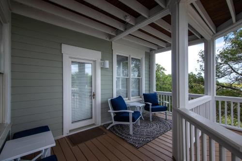 a porch with two chairs and a table on it at Tequila Sunset in Edisto Island