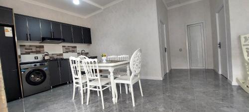 une cuisine avec une table et des chaises dans une cuisine dans l'établissement Hostel Qebele, à Qabala