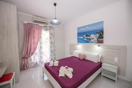 a bedroom with a purple bed with two dolls on it at Villa Eleni Holidays Resort - with Pool near the Beach in Sidari