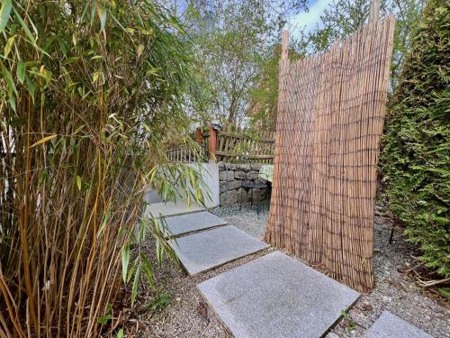 a wooden gate in a garden with a fence at Beim Thöny - schönes Apartment mit privatem Zugang in Utting am Ammersee