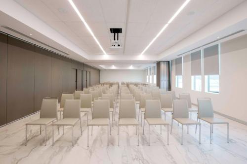 an empty room with rows of white chairs in it at NH Monterrey La Fe in Monterrey