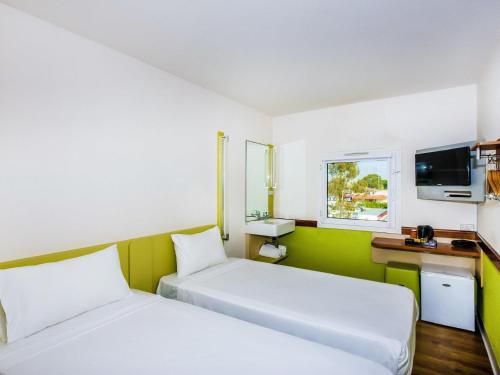 a hotel room with two beds and a television at ibis Budget - Melbourne Airport in Melbourne