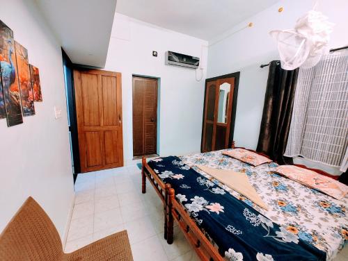 a bedroom with a bed and a wooden door at Gothra Beach Casa in Alleppey