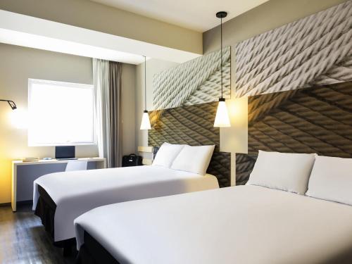 a hotel room with two beds and a window at Ibis Mexico Tlalnepantla in Mexico City