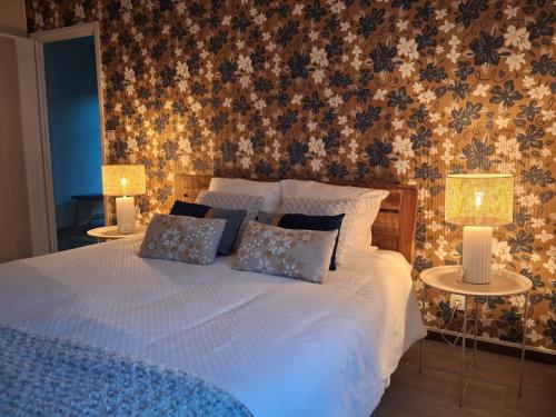 a bedroom with a bed with two tables and two lamps at Les mésanges bleu in Malmedy