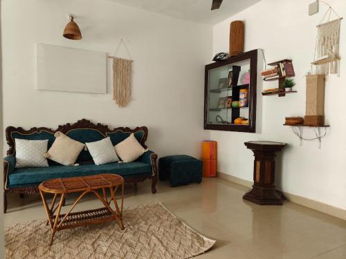 a living room with a blue couch and a table at Shamak Homestay Varkala in Varkala