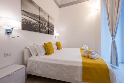 a bedroom with a bed with yellow and white pillows at Principe del Pardo in Catania