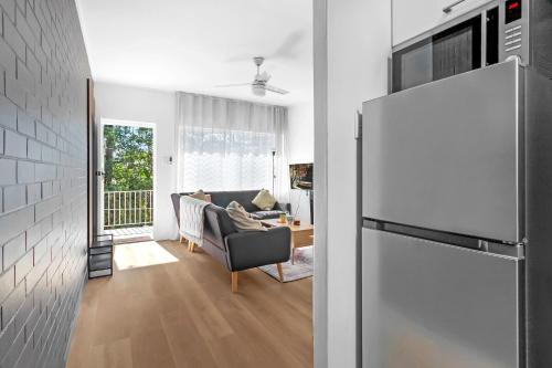 a living room with a couch and a refrigerator at Charming 2-Bed Near River & City in Brisbane