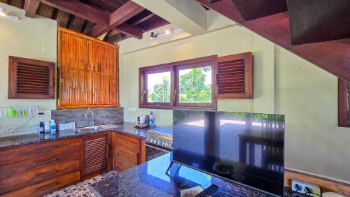 a kitchen with wooden cabinets and a counter top at Dalai Tropical in Kuta Lombok