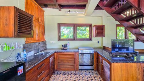 a kitchen with wooden cabinets and a counter top at Dalai Tropical in Kuta Lombok