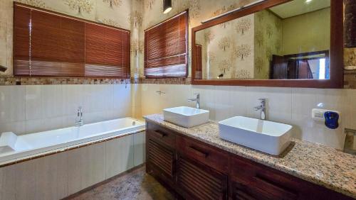 a bathroom with two sinks and a tub at Dalai Tropical in Kuta Lombok