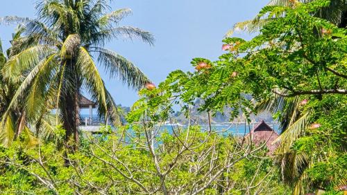 a view of the ocean through the trees at Dalai Tropical in Kuta Lombok