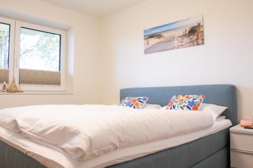 a bedroom with a bed with white sheets and a window at Schöne Tiet - Küste33 26 in Tossens